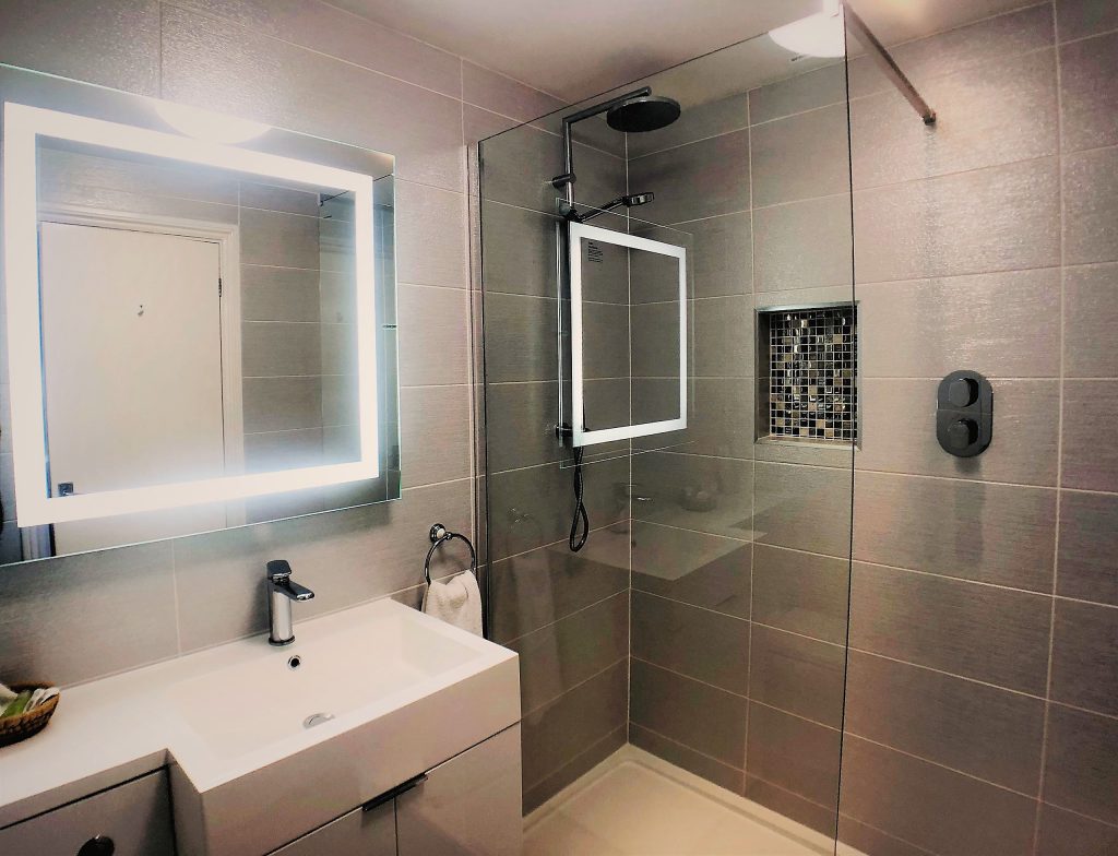 Walk-in rain shower with illuminated mirror